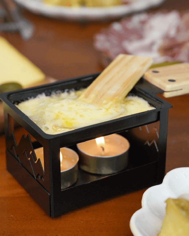 Raclette à la Bougie Pliable de Cookut, modèle compact pour fondre du fromage sans électricité, idéale pour des moments conviviaux.

